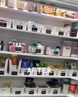 A walk-in pantry after organizing: white baskets and clear bins on every shelf, each with a chalkboard label